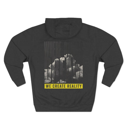 Back of the charcoal heather Where Others Dream Fleece Pullover Hoodie with the city skyline graphic and yellow We Create Reality banner.