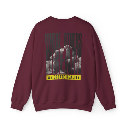Back of the maroon Where Others Dream Crewneck Sweatshirt with the city skyline graphic and yellow We Create Reality banner.