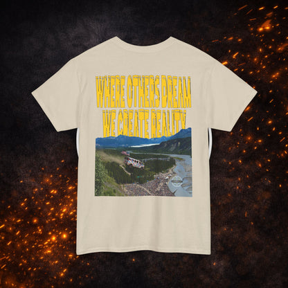 Back view of the sand Lucid Reality Where Others Dream Tee showing the "Where Others Dream We Create Reality" yellow text above a mountain and river landscape graphic.