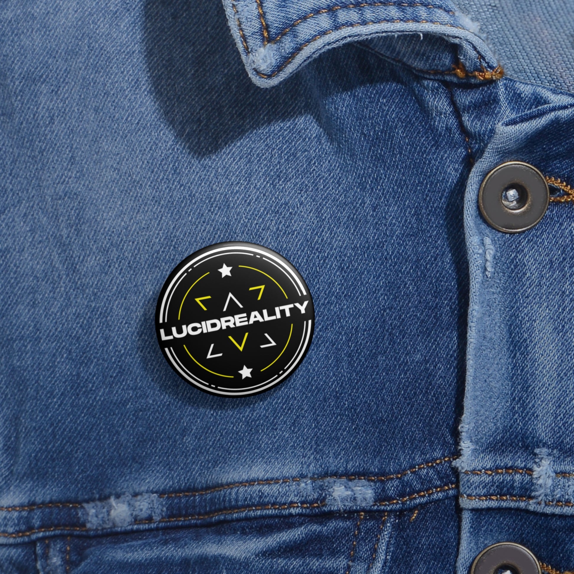 Lucid Reality logo pin-back button pinned to a denim jacket