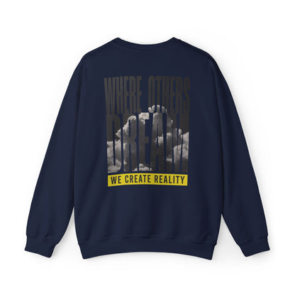Back of the navy Where Others Dream Crewneck Sweatshirt with the city skyline graphic and yellow We Create Reality banner.