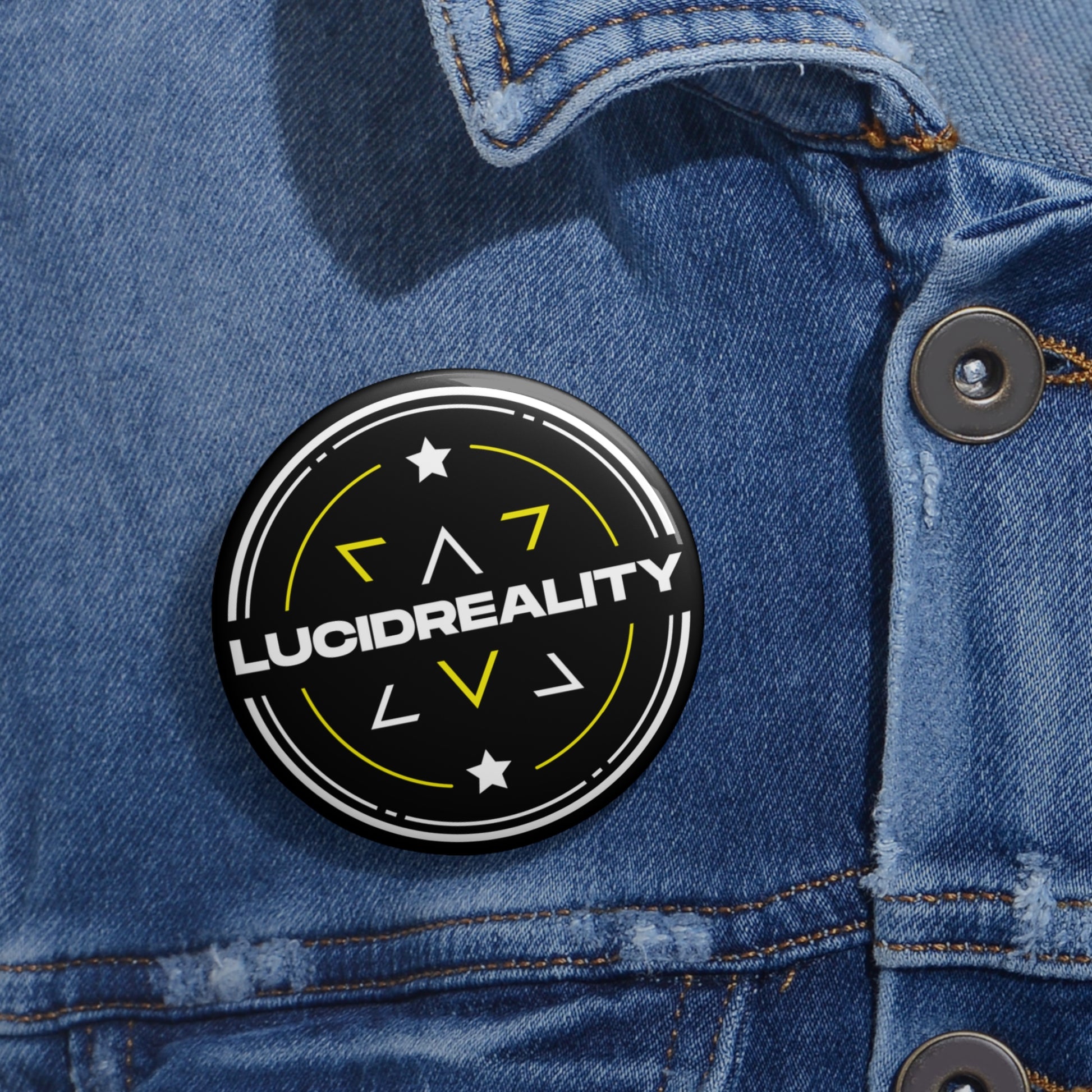 Lucid Reality logo pin-back button pinned to a denim jacket pocket