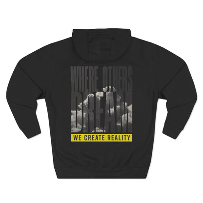 Back of the black Where Others Dream Fleece Pullover Hoodie with the city skyline graphic and yellow We Create Reality banner.