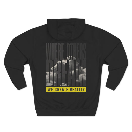Back of the black Where Others Dream Fleece Pullover Hoodie with the city skyline graphic and yellow We Create Reality banner.