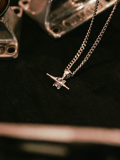 Sterling silver skateboard truck pendant on a Cuban chain, curated by Lucid Reality