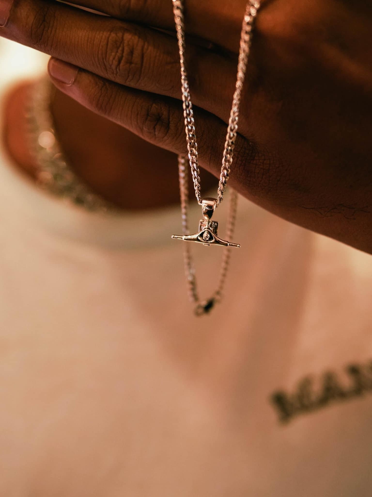 Sterling silver skateboard truck pendant on a Cuban chain, curated by Lucid Reality