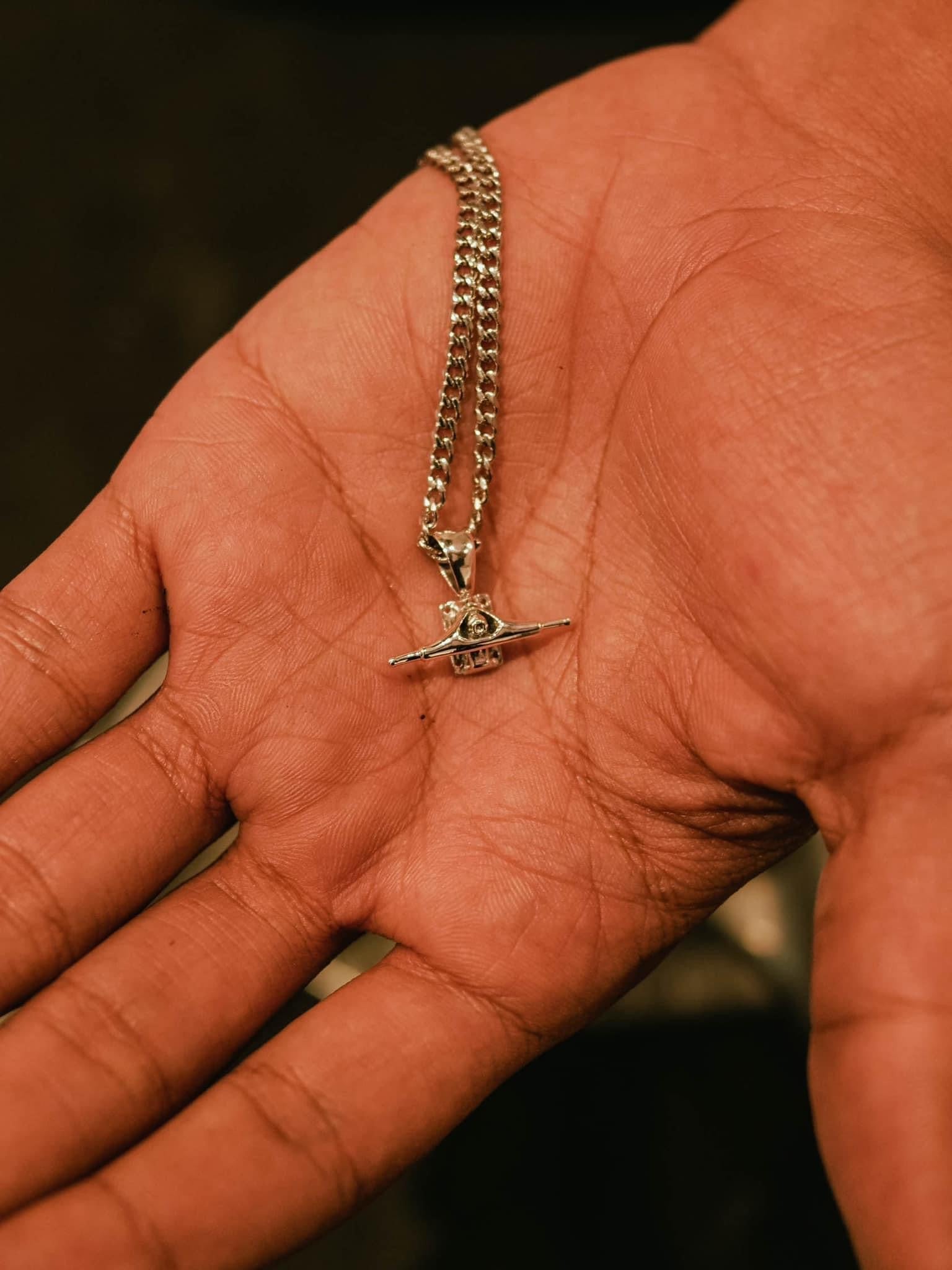 Sterling silver skateboard truck pendant on a Cuban chain, curated by Lucid Reality