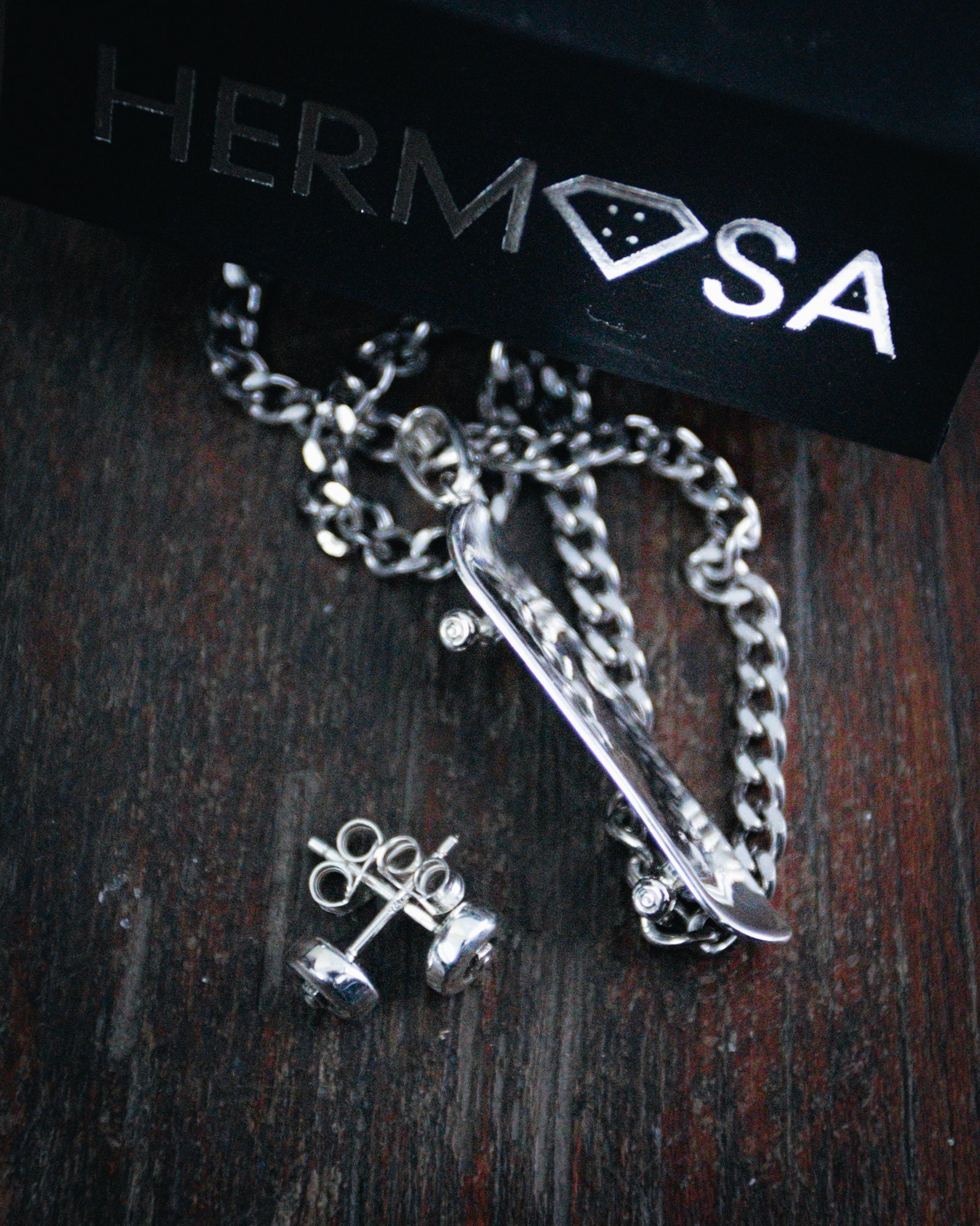 Sterling silver skateboard deck pendant with wheel stud earrings, curated by Lucid Reality