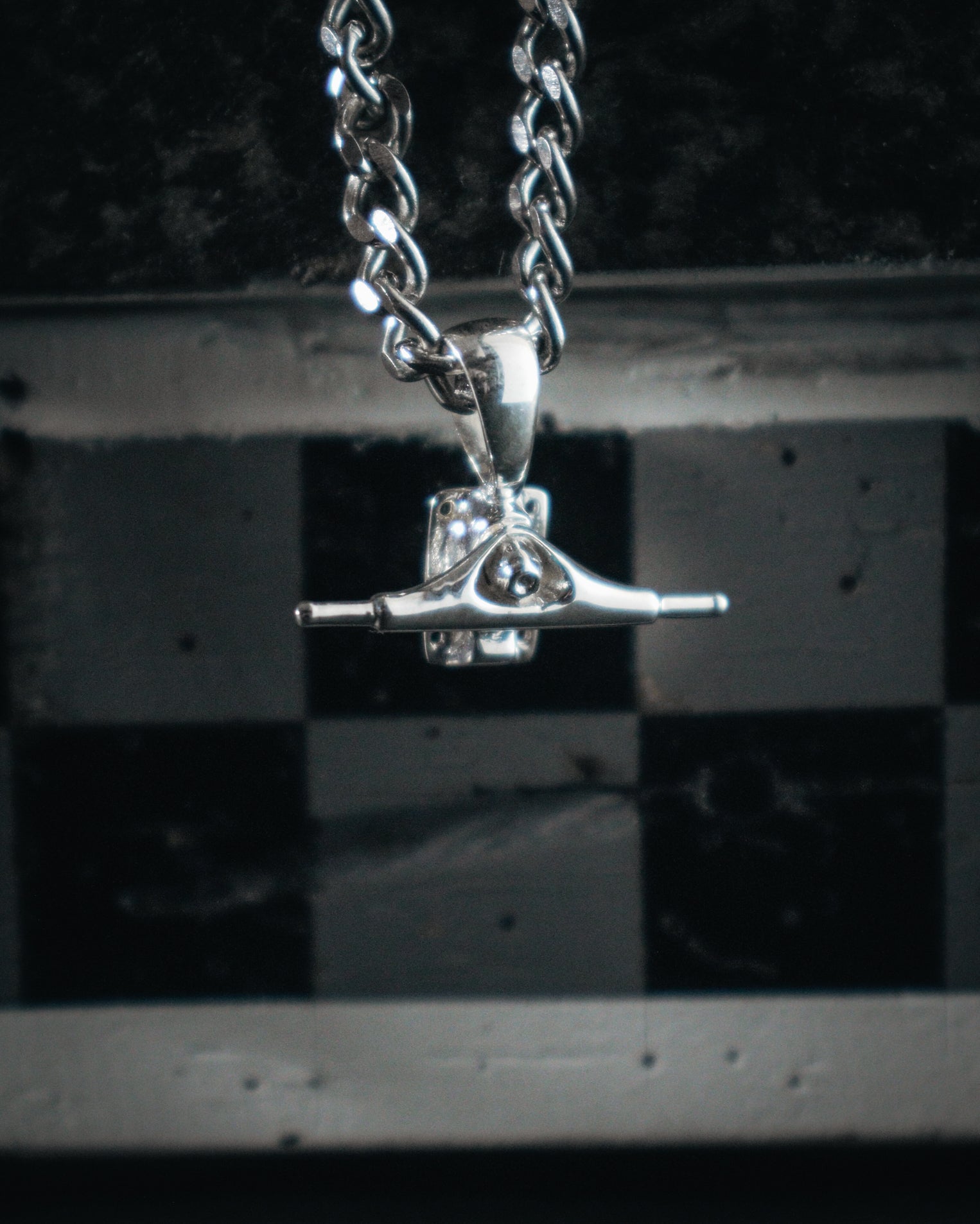 Sterling silver skateboard truck pendant on a Cuban chain, curated by Lucid Reality