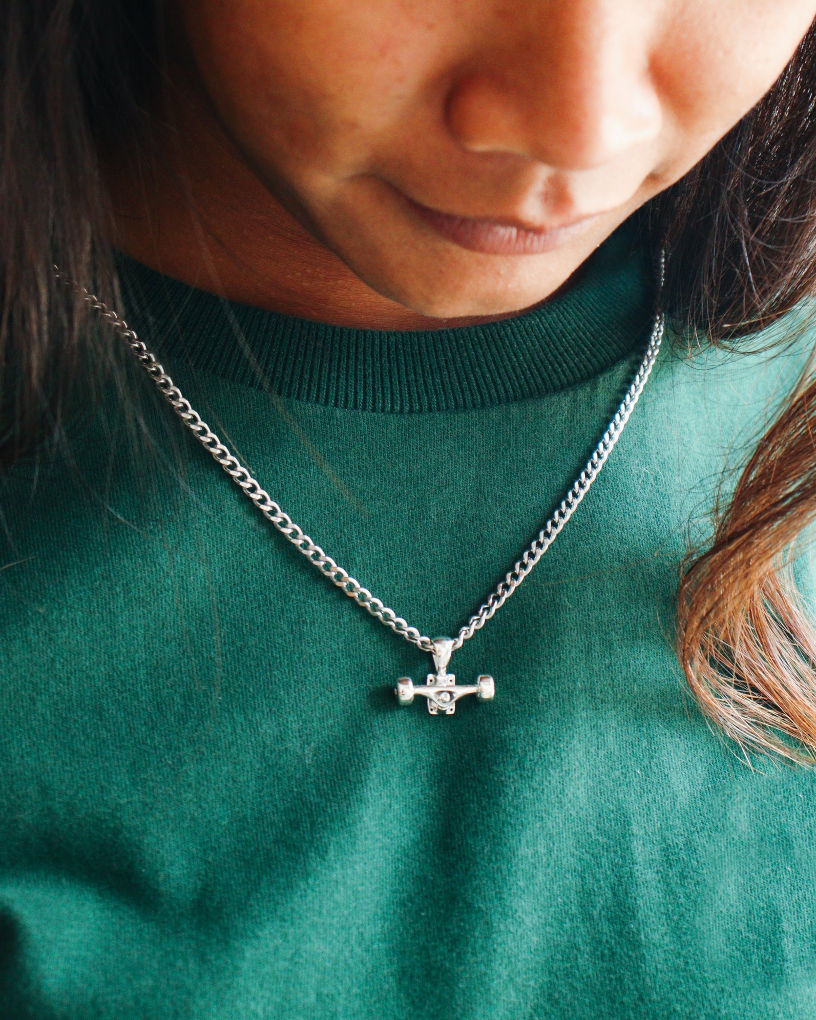 Sterling silver skateboard truck with wheels pendant on a Cuban chain, curated by Lucid Reality