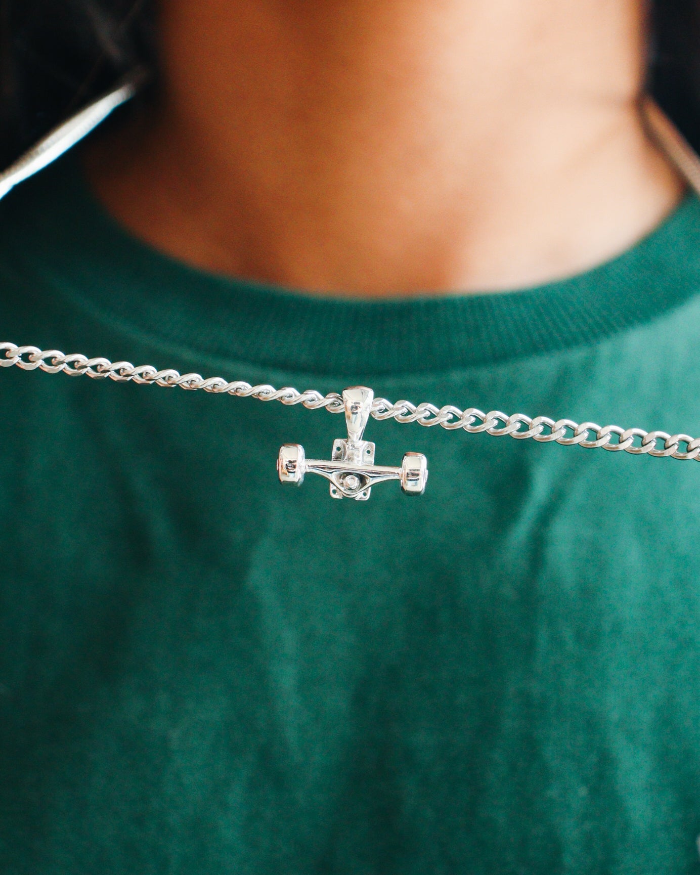 Sterling silver skateboard truck with wheels pendant on a Cuban chain, curated by Lucid Reality