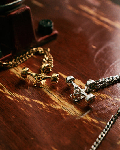 Sterling silver skateboard truck with wheels pendant on a Cuban chain, curated by Lucid Reality
